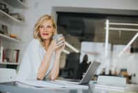 Beautiful smiling Caucasian businesswoman drinking coffee.