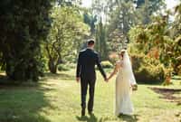 Happy bride and groom holding hands and