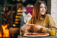 Young pretty woman eating pizza at a
