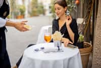 Waiter serving table for a young woman