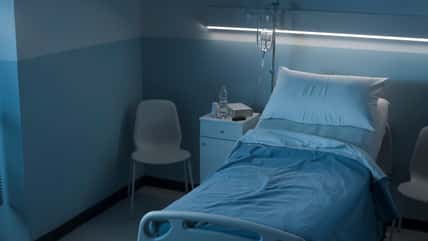 Clean hospital room interior at night with bed and medical equipment, medicine and healthcare concept