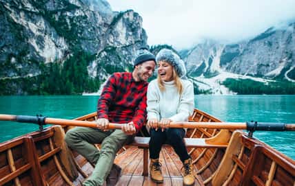 Mountain stories. Happy couple on a wanderlust vacation. Boyfriend and girlfriend spending time together at the lake. Storytelling concept about lifestyle and winter travels