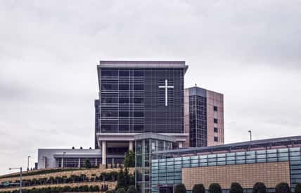 Hospital in Tulsa OKlahoma sitting up on a landscaped hill with giant cross on front windows