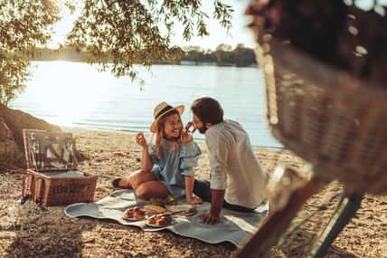 A young couple having a picnic at the beach