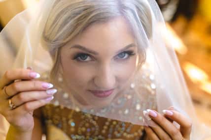 Beautiful blonde bride waiting her groom in wedding day indoors
