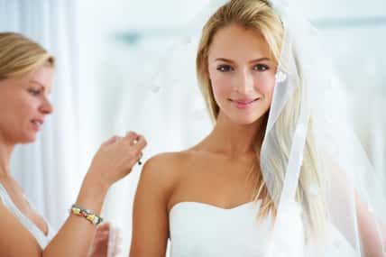 Bride smiling while wearing a wedding dress and veil.