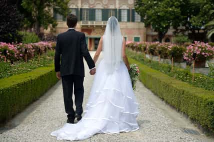 Bride and groom walking towards a villa.