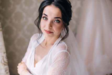 Luxury bride in white dress posing while preparing for the wedding ceremony