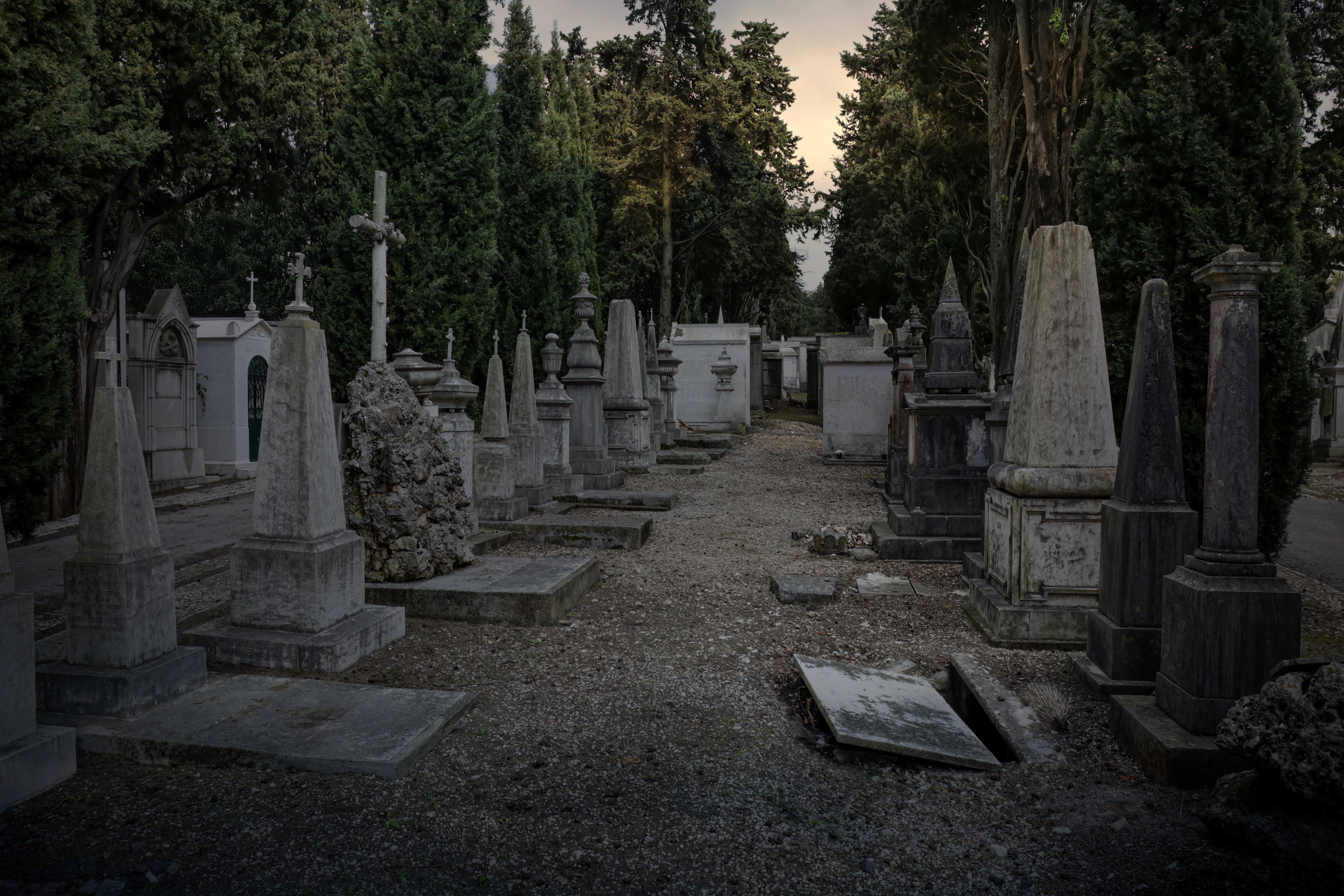 Old european cemetery at sunset seeing a creepy open grave in the foreground