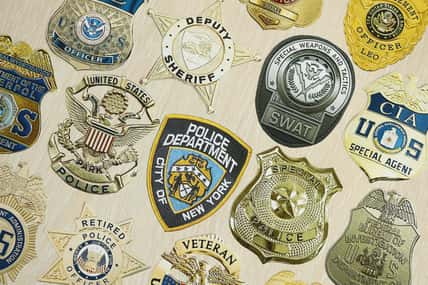 Badges of different United States police departments printed on paper close up