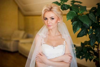 Blonde bride in amazing white dress at home