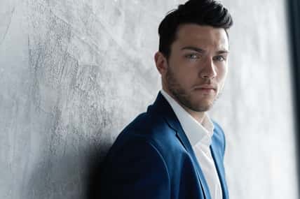 Handsome man wear blue suit isolated on grey background