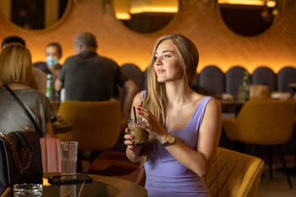Attractive young woman holding iced coffee