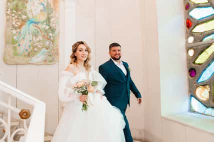 happy bride and groom on the stairs in the solemn hall of the registry office. Official registration of marriage.