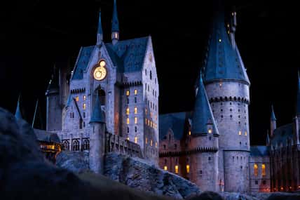 JAPAN - Nov 13, 2023: Closeup night view of Hogwarts Castle's clock tower illuminated beautifully highlighting its magical architecture at Warner Bros. Studio Tour Tokyo, The Making of Harry Potter