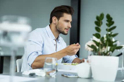 Handsome man eating meal
