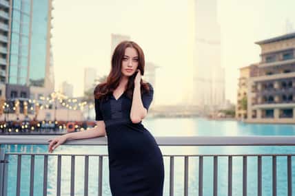 Portrait of beautiful caucasian woman with charming smile and long hair walking on the Dubai street.