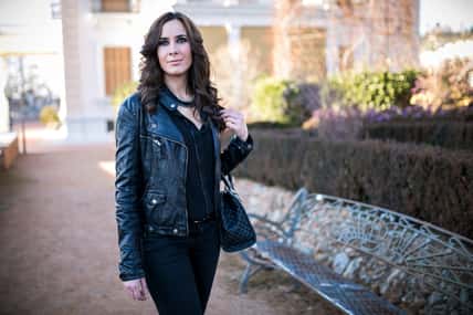 brunette woman dressed in black in a park