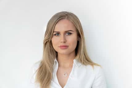 Blonde woman in white blouse. Smiling, confident, content, happy, pretty.