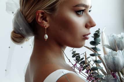 Facial portrait of a bride with a bouquet. Bride morning. White background.
