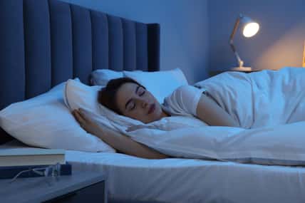Beautiful young woman sleeping in bed at night
