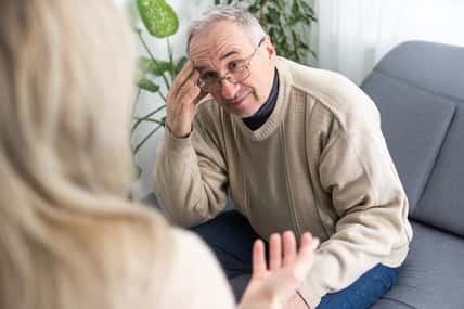 Mature man at a session with a psychologist. The doctor listens and writes. Help with depression, psychiatric diagnosis