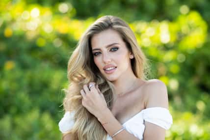 Beautiful woman enjoying spring. Attractive tender romantic girl on spring green nature background. Beautiful young woman with glamour make up outdoor portrait