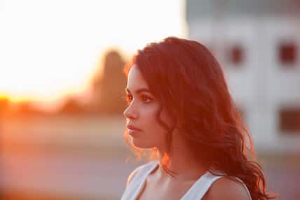 Beauty Sunshine Girl Portrait. Sunny Summer Day under the Hot Sun. Happy Woman Smiling and looking at camera.