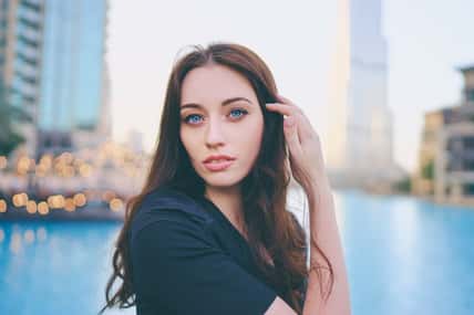 Close-up portrait of beautiful caucasian woman with charming smile and long hair walking on the Dubai street.
