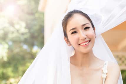 Beautiful Attractive Asian Bride Woman wearing wedding dress and holding bouquet smile and happiness in wedding day