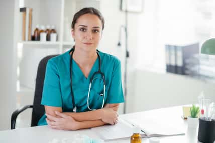 Young female doctor in medical office. Portrait of beautiful female doctor sitting in the clinic office.