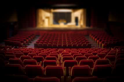 Empty red armchairs of a theater ready for a show