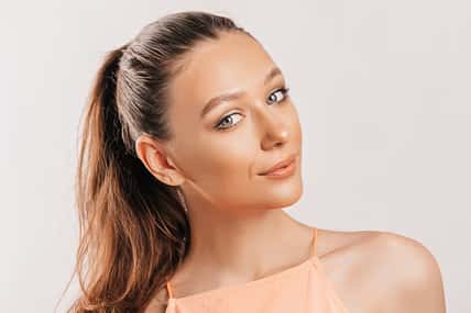 Beautiful young girl smiling and posing looking at the camera on a white isolated background. Positive brunette woman. Kind look. Beauty face.
