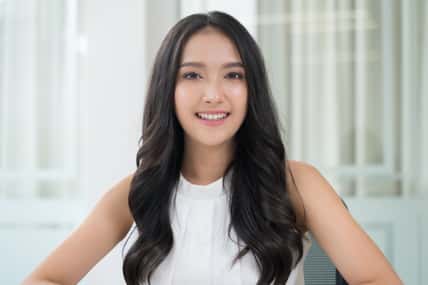 Close up portrait young Asian woman smiling in office