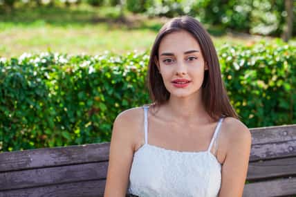 Close up portrait of a young beautiful brunette girl in summer park