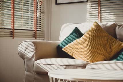 Close up pillow on sofa at home in morning with sunlight.Furniture in house background with light shade on object.
