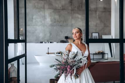 Bride in a white dress with a bouquet of flowers. Wedding preparations. Bride morning.