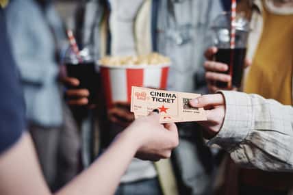 Unrecognizable people giving tickets for movie to