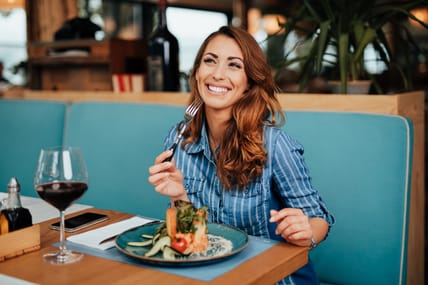 Young beautiful and happy woman enjoying in delicious meal in luxurious restaurant.