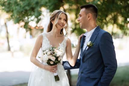 the first meeting of the bride and groom in wedding outfits in the park
