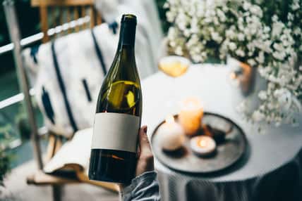Wine bottle in hand. Blank label