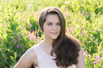 Portrait of a girl of 16 years in the flower meadow