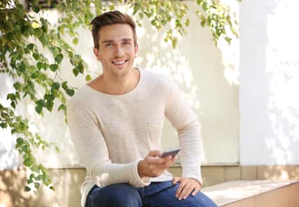 Young man talking on phone in the yard