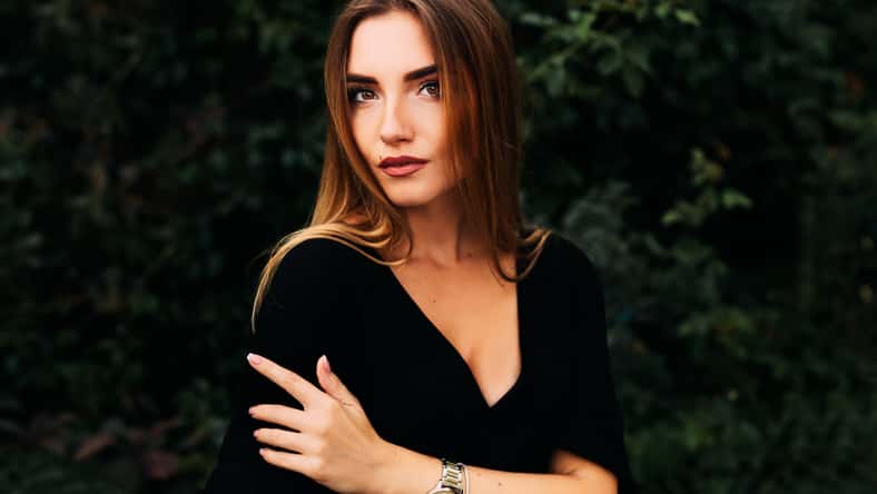 young brunette woman in black dress. beautiful makeup. girl on a