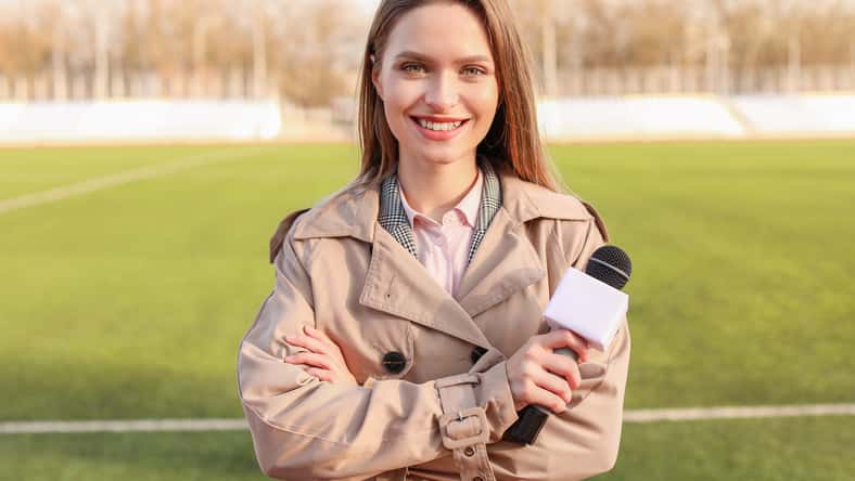 Beautiful reporter with microphone at the stadium