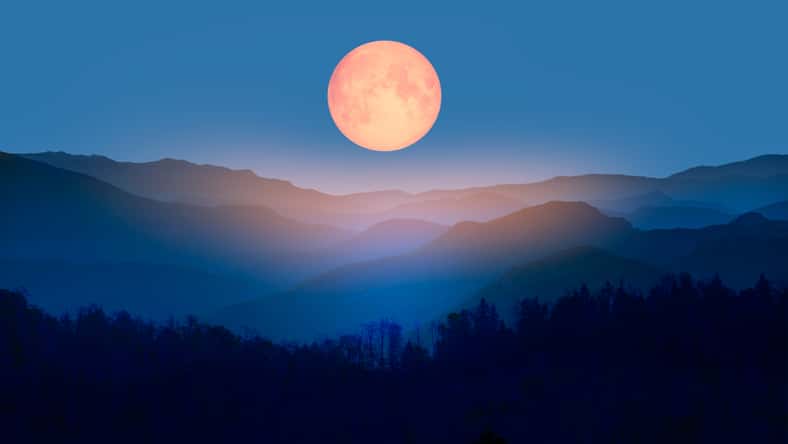 Beautiful landscape with blue misty silhouettes of mountains against super blue moon "Elements of this image furnished by NASA"