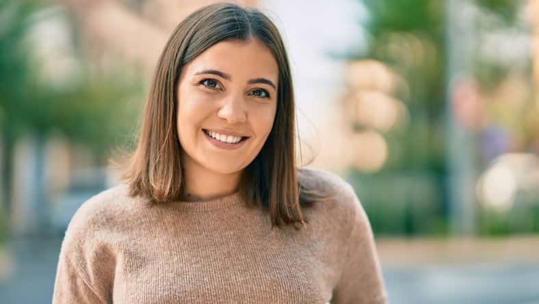 Young hispanic woman smiling happy standing at the city.