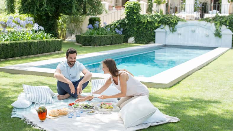 Couple enjoying picnic by pool