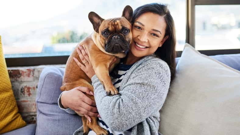 Portrait of a young woman relaxing with her dog at home.