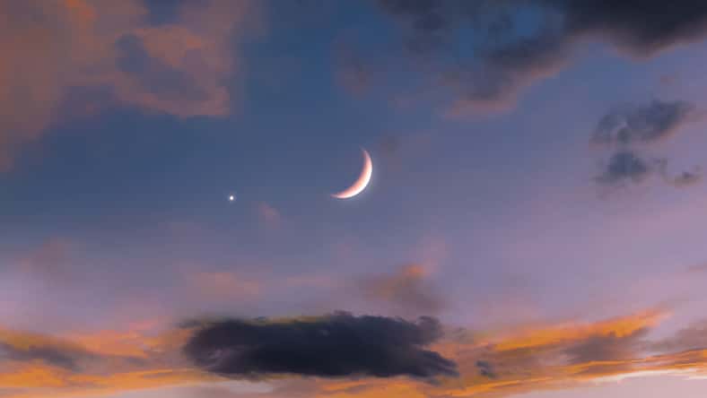 New moon in the sky near Venus at sunset. Venus next to the Moon. Beautiful celestial landscape.